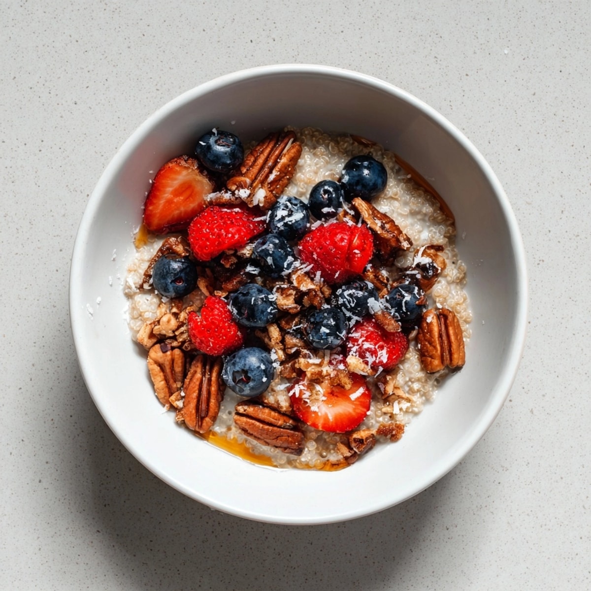 Nahaufnahme von Maple Pecan Frühstücks-Quinoa: ein köstliches, glutenfreies und vegetarisches Frühstück mit Ahornsirup und gerösteten Pekannüssen.