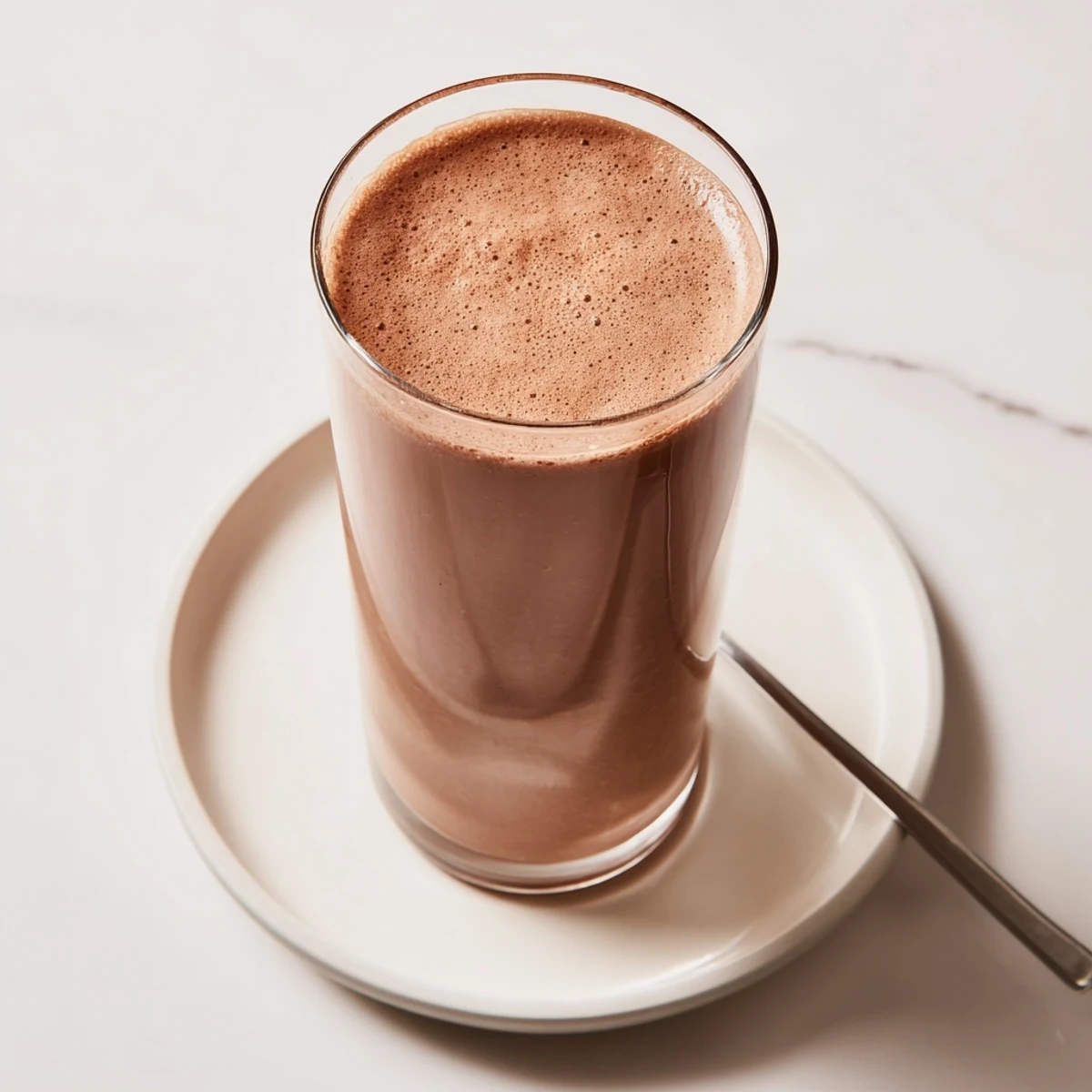 Homemade chocolate milk recipe, combining cocoa and cold milk for a simple, quick beverage.