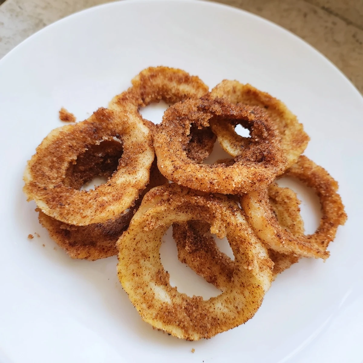 Close-up of baked spiced apple chips, showcasing their crispy texture with warm, inviting spices.