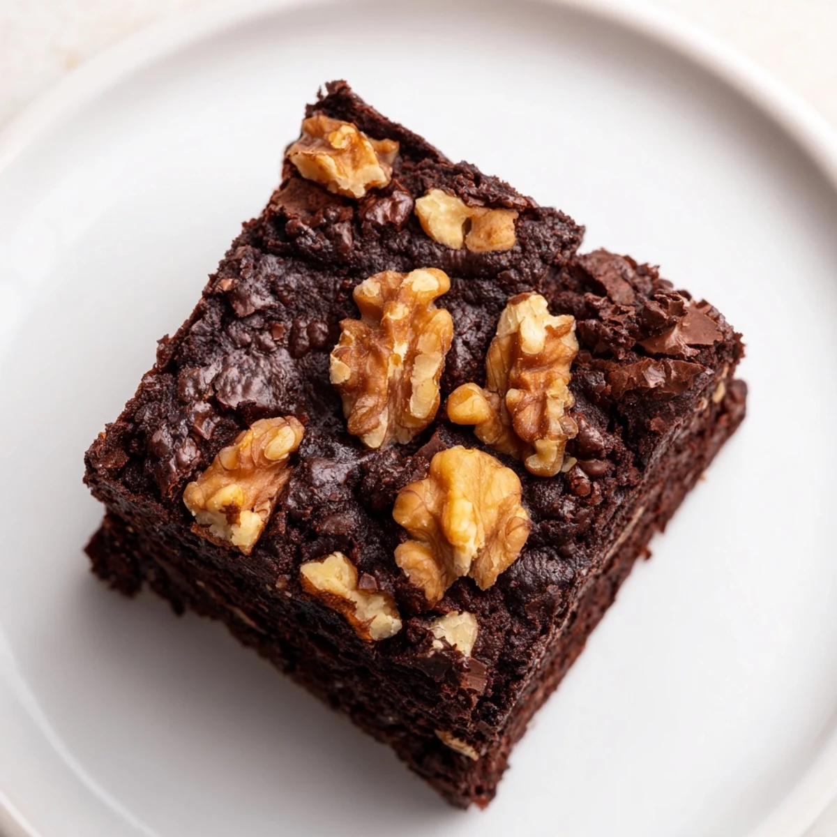 Fudgy Chocolate Fudge Brownies with Chopped Walnuts on a rustic wooden table with vanilla ice cream.