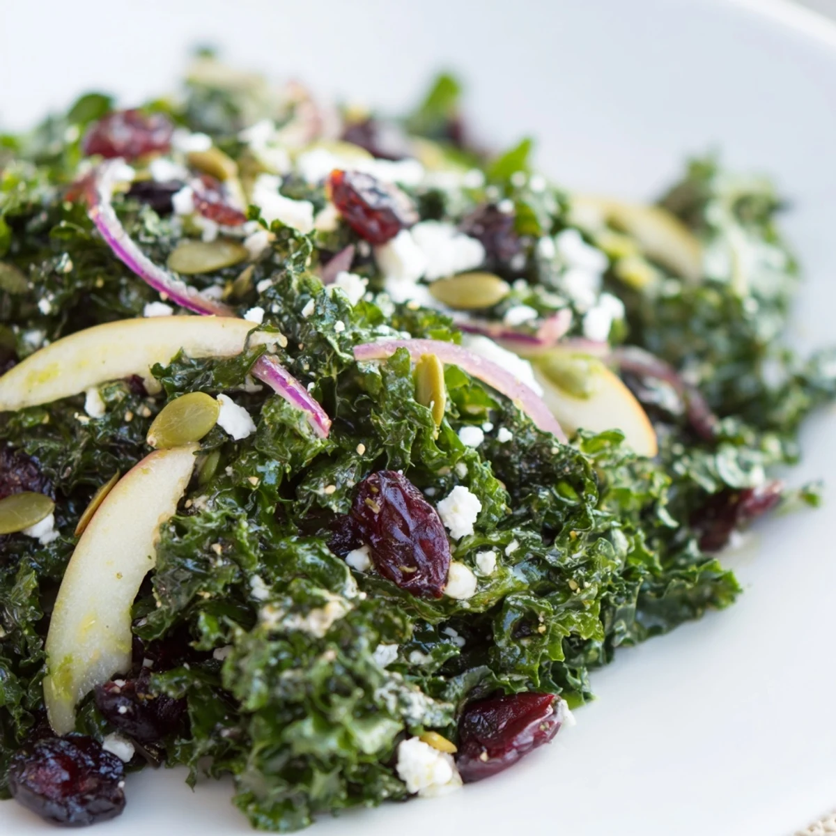 Freshly tossed Winter Kale Salad with Cranberries and Seeds topped with crunchy pumpkin and sunflower seeds.