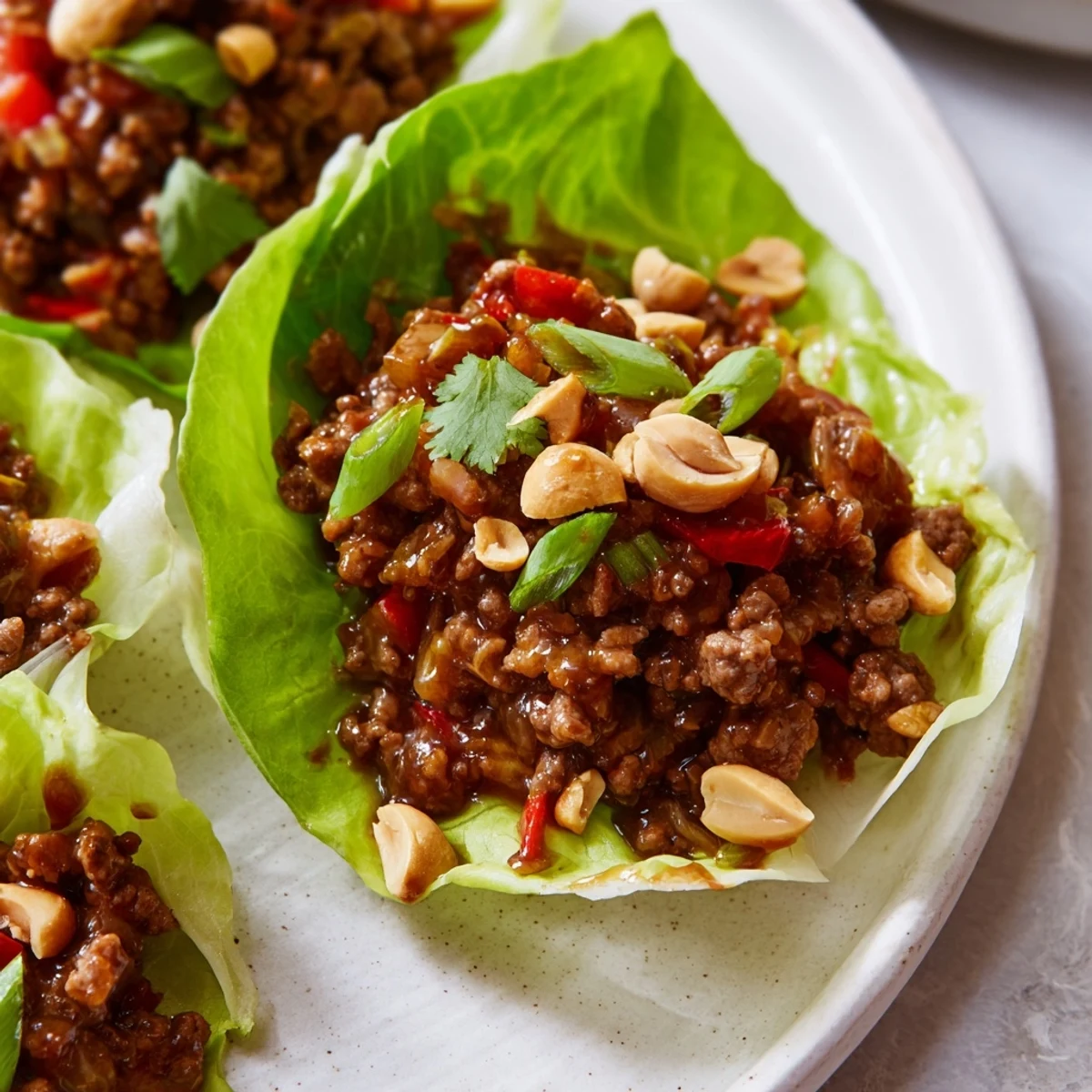 Gehackte Erdnüsse und frische Kräuter auf zarten Butterlettucche-Blättern mit Füllung.