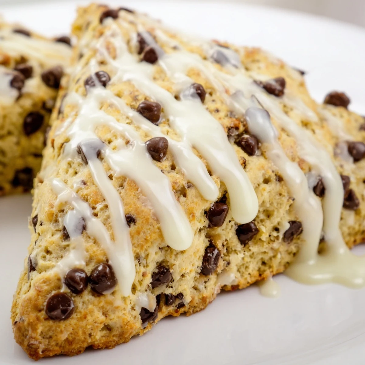 Warm Chocolate Chip Scones with Sweet Vanilla Glaze, fresh from the oven and drizzled with creamy glaze
