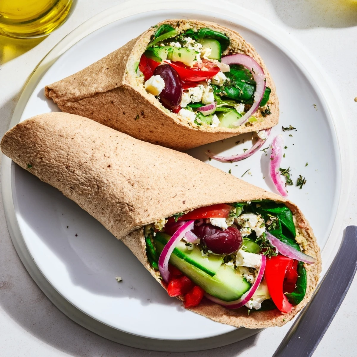 Hochwertiges Foto eines frischen mediterranen Sandwich-Wraps, gefüllt mit bunten Gemüsescheiben und Feta-Krümeln auf einer rustikalen Holzplatte.