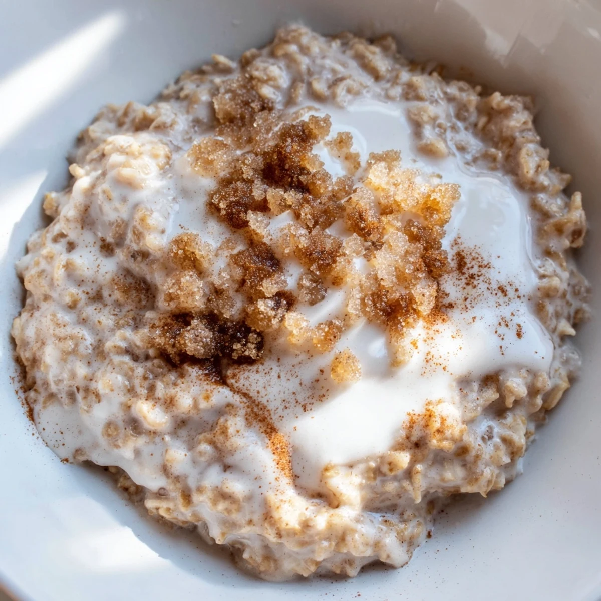 Dampfende Schüssel Irish Oatmeal with Brown Sugar and Cream mit zuckerhaltiger Noten und cremiger Sahne zum Frühstück.