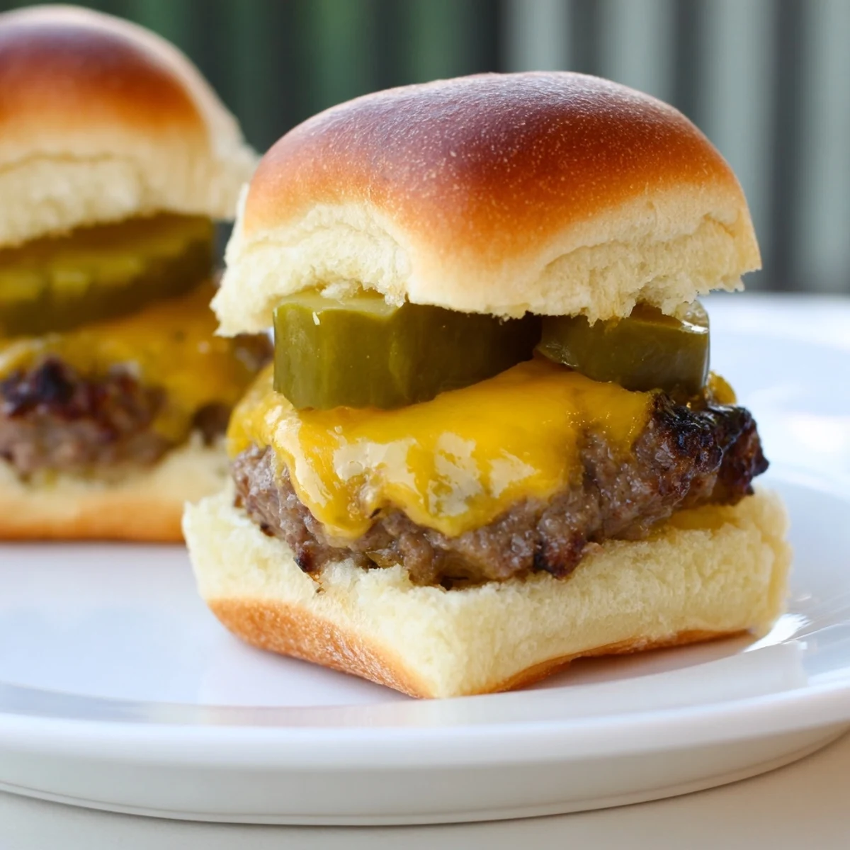 Beef Sliders with Cheese and Pickles werden warm serviert, begleitet von Pommes und kühlem Getränk für das ganze Haus.