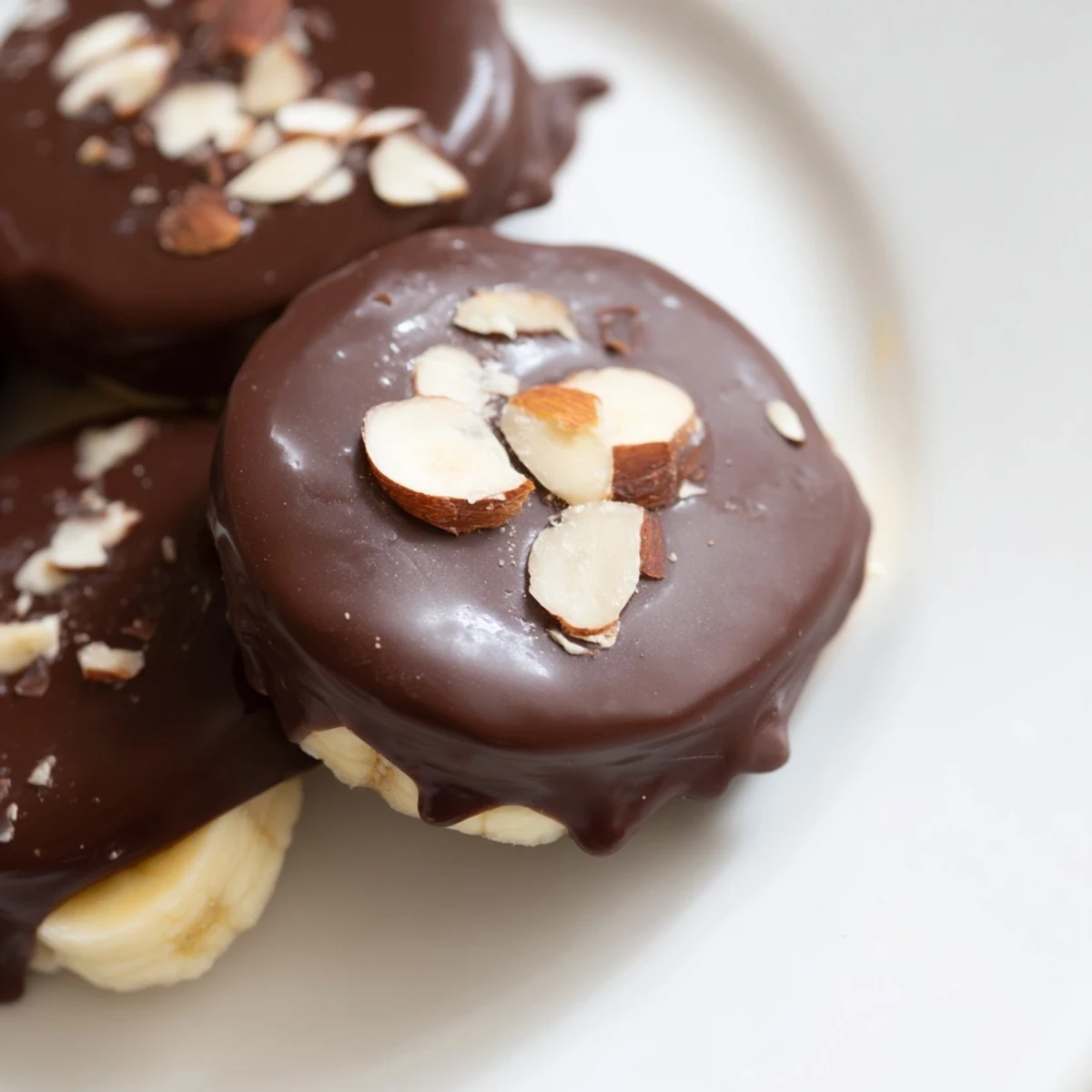 Frozen banana slices coated in rich chocolate for these Chocolate Covered Banana Bites, sprinkled with nuts.