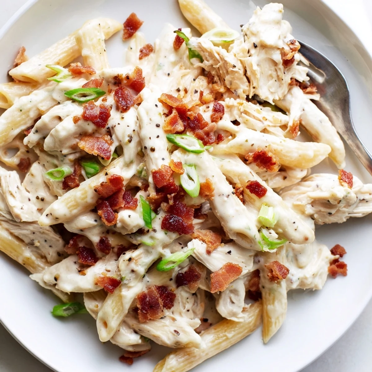 Warmes Crack Chicken Pasta in weißer Soße mit frischen grünen Zwiebeln bestreut