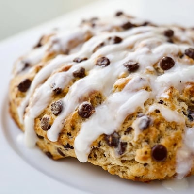 A platter of glazed Chocolate Chip Scones with Sweet Vanilla Glaze served for breakfast with coffee